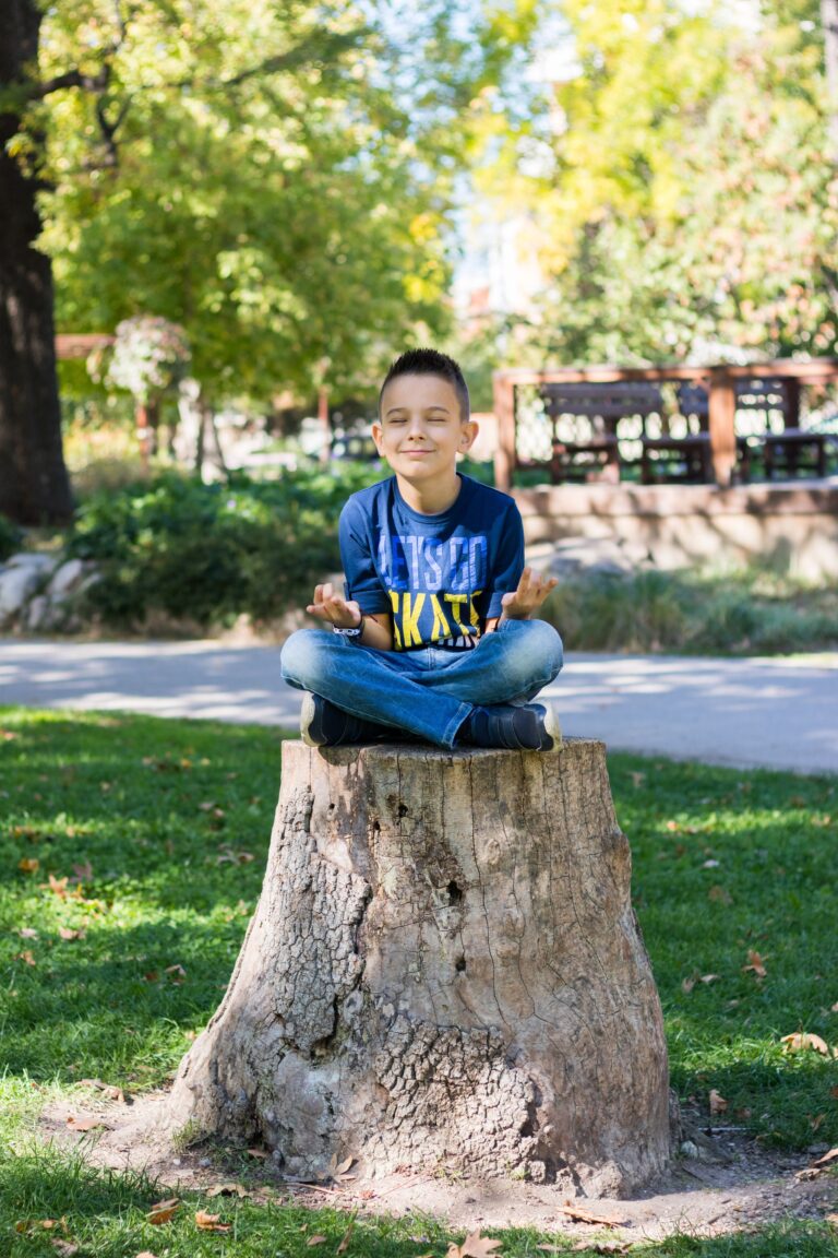 boy meditating on a stump